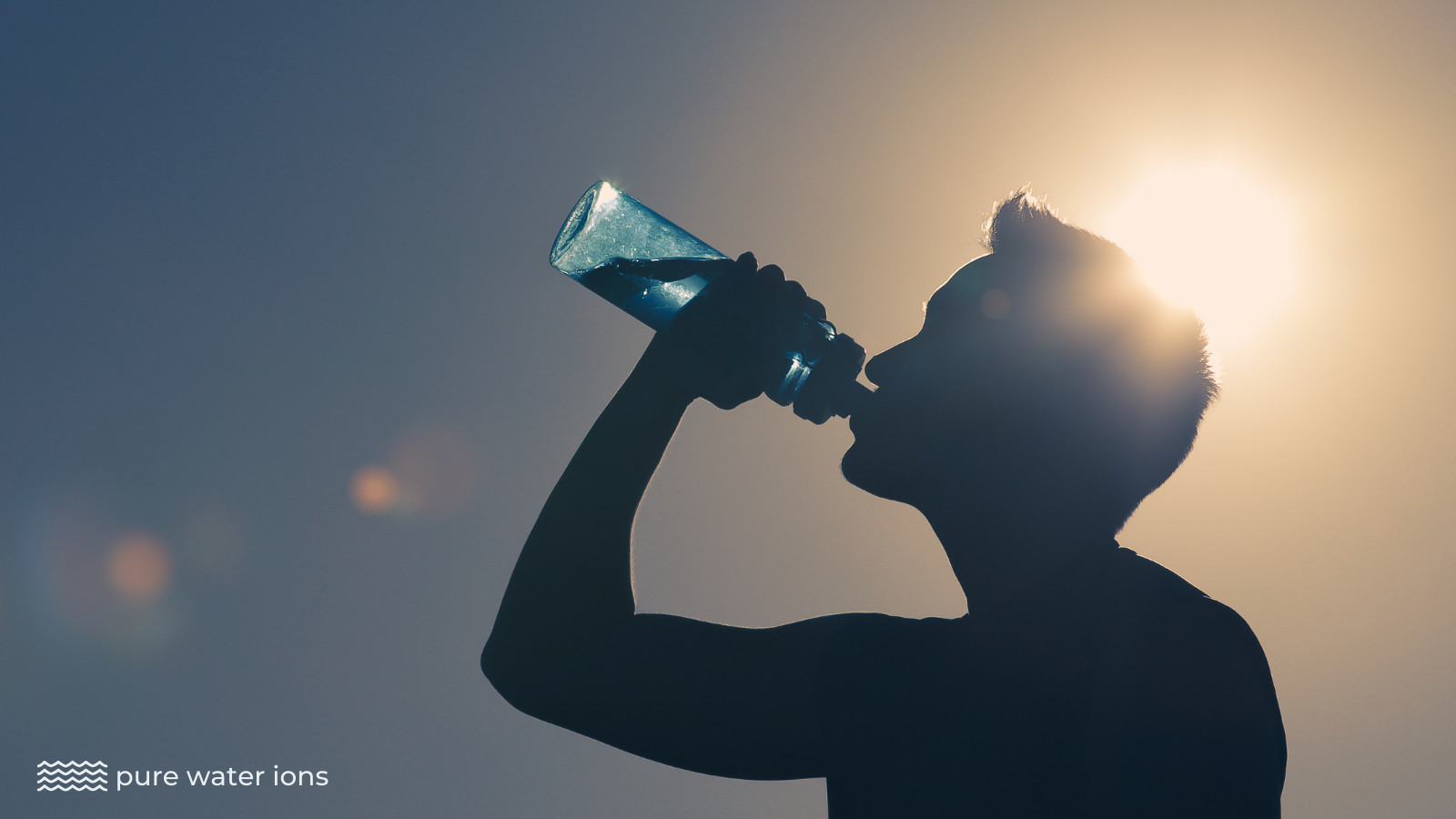man drinking a bottle of water in the sunshine
