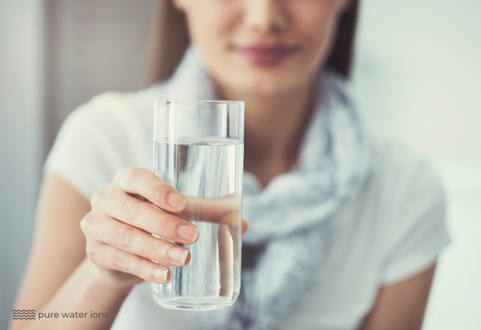 lady holding a glass of reverse osmosis filtered water