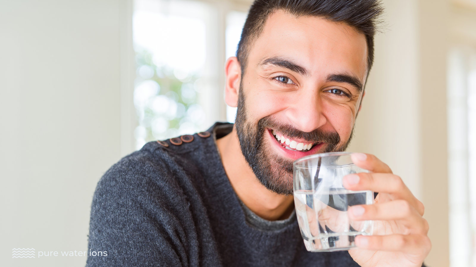 man drinking a glass of ionized water