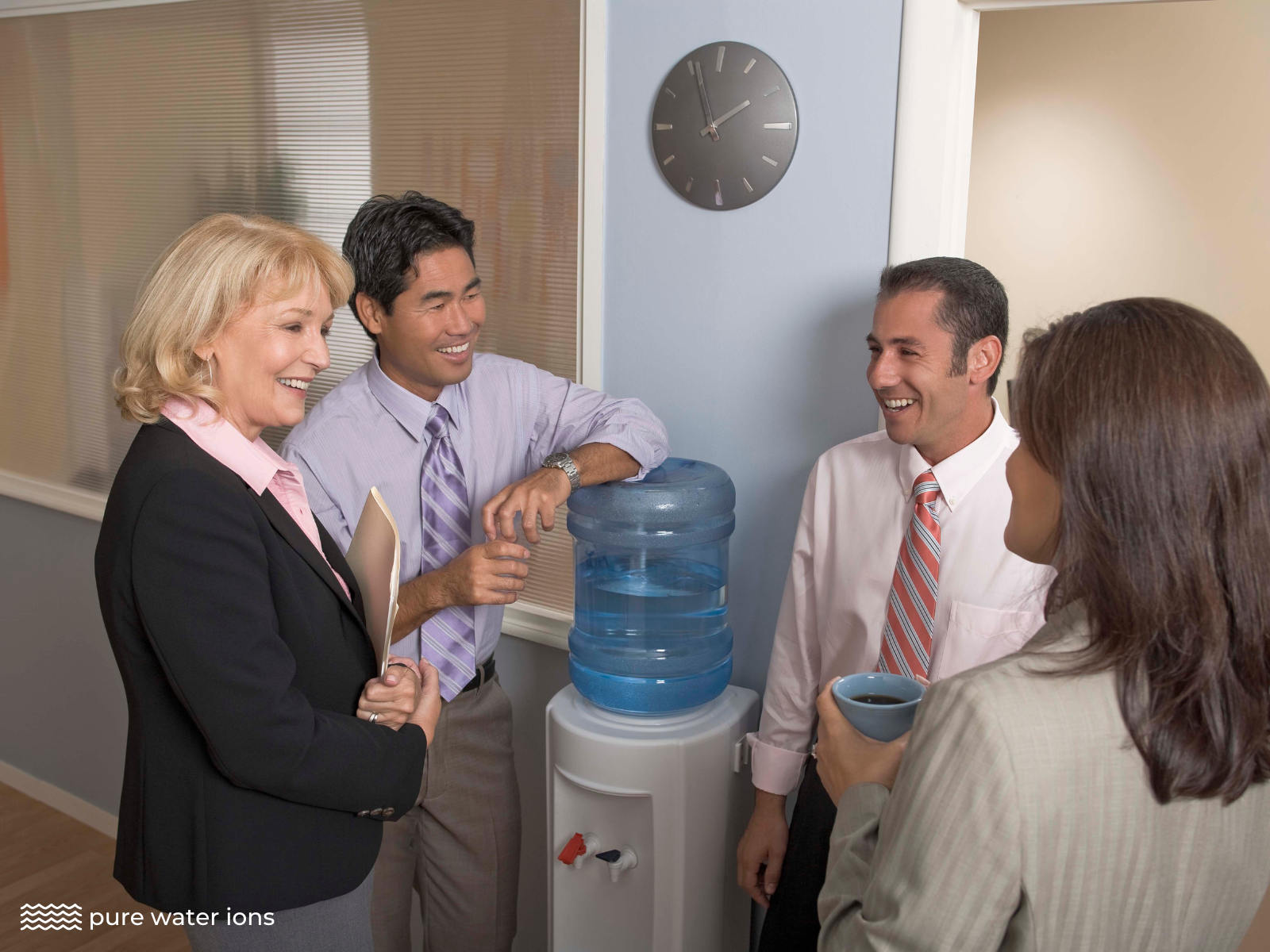 workers smiling and chatting at a water cooler